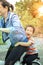 Happiness face of asian children playing on bicycle with mother for families relationship