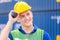 Happiness foreman in hardhat and safety vest talks on two-way radio control loading containers box from cargo