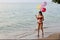 Happiness on holiday image of young asian beautiful and sexy girl in red bikini who holding balloons and running on sandy beach