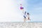 Happiness lover couple holding colorful balloons and jumping with smile on the tropical beach in sunny day