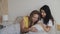 Happiness of motherhood, asian and white women in love. Multiracial lesbian couple expecting a baby, lying in bed. Big