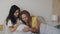 Happiness of motherhood, asian and white women in love. Multiracial lesbian couple expecting a baby, lying in bed. Big