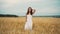 Happiness, nature, summer holidays, vacation and people concept - young woman in white dress walking along cereal field