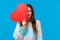 Happiness, relationship and love concept. Carefree happy good-looking woman holding big cute red heart sign over half