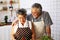 Happiness senior elderly couple having fun in kitchen with healthy food for working from home.