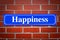 Happiness street sign on brick wall