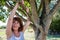 Happy 50s woman under tree for metaphor of serenity