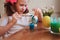 Happy 7 years old kid girl painting easter eggs. Easter craft and holiday preparations