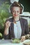 happy accountant woman in green office eating salad