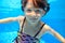 Happy active child swims underwater in pool