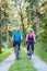 Happy and active senior couple riding bicycles outdoors in the p