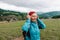 Happy active senior tourist woman listening to music in outdoor leisure trip admiring the landscape feeling inspired by