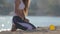 Happy active sport young woman playing with little chihuahua dog using yellow flying disc on sand beach near summer sea