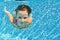 Happy active underwater child swims and dives in pool