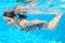 Happy active underwater child swims in pool