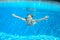 Happy active underwater child swims in pool