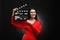 Happy actress with clapperboard on black background. Film industry