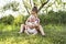 Happy adorable chubby baby girl sitting on the grass with her daughter sister