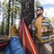 Happy adult caucasian couple enjoy the nature outdoor leisure camping activity - woman legs pov on hammock and man standing with