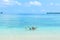 Happy adult couple having fun in turquoise water wearing snorkeling mask. Real people bathing in caribbean sea on tropical beach,