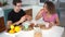 Happy adult couple sitting at dining table in kitchen and eating breakfast