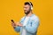 Happy adult european guy in headphones enjoying favorite music, typing on smartphone