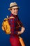 Happy adventure tourist woman with backpack isolated on blue