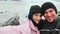 Happy adventurous couple taking selfie in front of glacier lagoon in Iceland. Two tourists having fun on romantic winter vacation