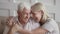 Happy affectionate senior old couple embracing bonding looking at camera