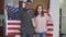 Happy African American adult man and teen girl posing with USA flag smiling and hugging. Portrait of cheerful proud