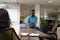 Happy african american businesman sitting on desk discussing with biracial businesswoman