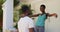 Happy african american couple holding keys embracing outside house with packing boxes