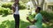 Happy african american couple in sunny garden man kneeling holding ring proposing to woman