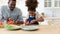 Happy African American daughter kid helping dad to prepare dinner