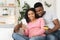 Happy african american expecting family using smartphone for online shopping