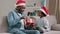 Happy african american family celebrating christmas dad with daughter sitting at home on sofa cute loving kid girl