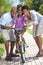 Happy African American Family & Girl Riding Bike