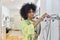 Happy African-American fashion designer takes cardboard basic pattern in sewing workshop