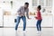 Happy african american father and daughter dancing at kitchen