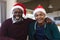 Happy african american father and son in christmas hats having video call, smiling