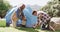 Happy african american father and son pitching tent together in sunny countryside, slow motion