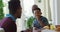 Happy African American grandfather, father and son sitting at dining table