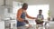 Happy african american grandfather and grandson baking, using tablet in kitchen, slow motion