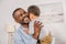 happy african american grandfather hugging adorable little grandchild