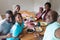 Happy african american grandfather taking selfie with grandchildren and their parents at family meal