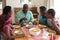 Happy african american grandfather talking with grandchildren and their parents at family meal