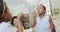 Happy african american grandmother with adult daughter and granddaughters blowing bubbles