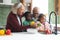 Happy african american grandparents and grandchildren washing vegetables in kitchen, slow motion