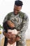 Happy african american male soldier embracing daughter at home, copy space