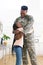 Happy african american male soldier embracing daughter at home, copy space